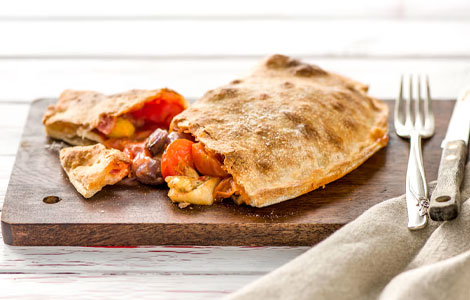 Di Vito’s Calzone cut in half to show the filling of cheese, tomatoes and other ingredients.